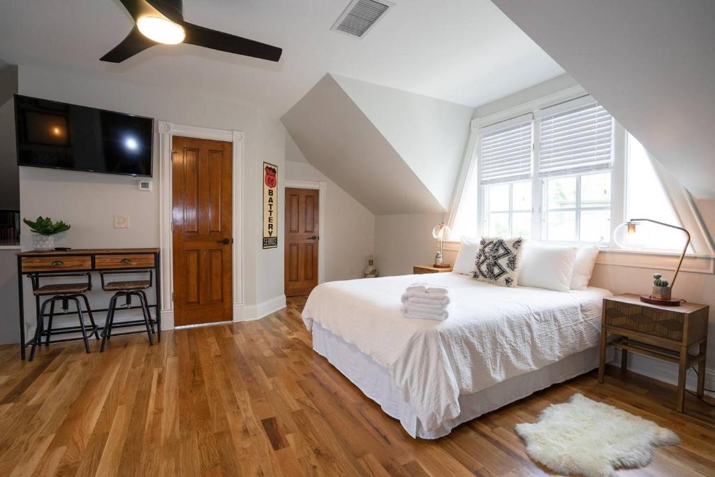 a bedroom with a large white bed and a kitchen at Smiths Crescendo in Denver