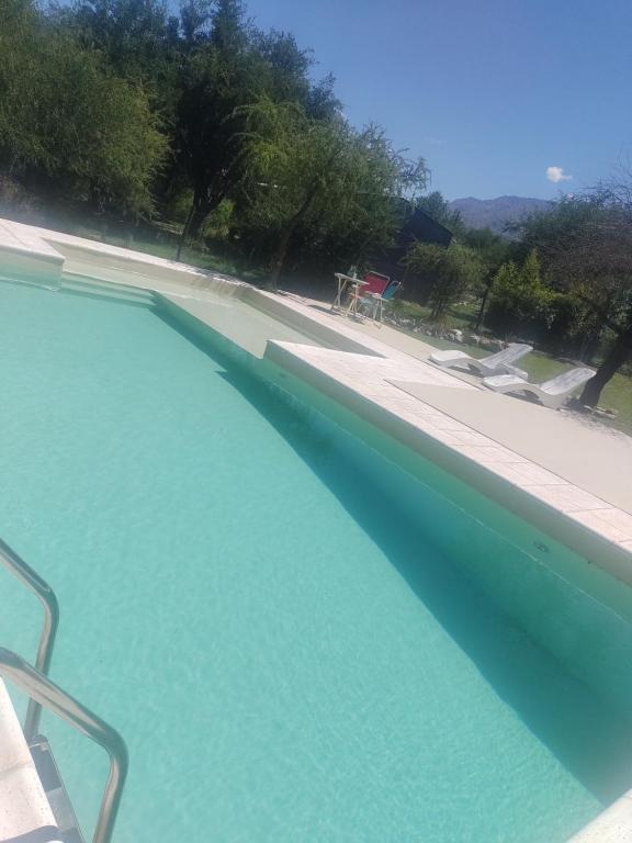 a swimming pool with blue water next to a patio at Aires de Ambar in Merlo