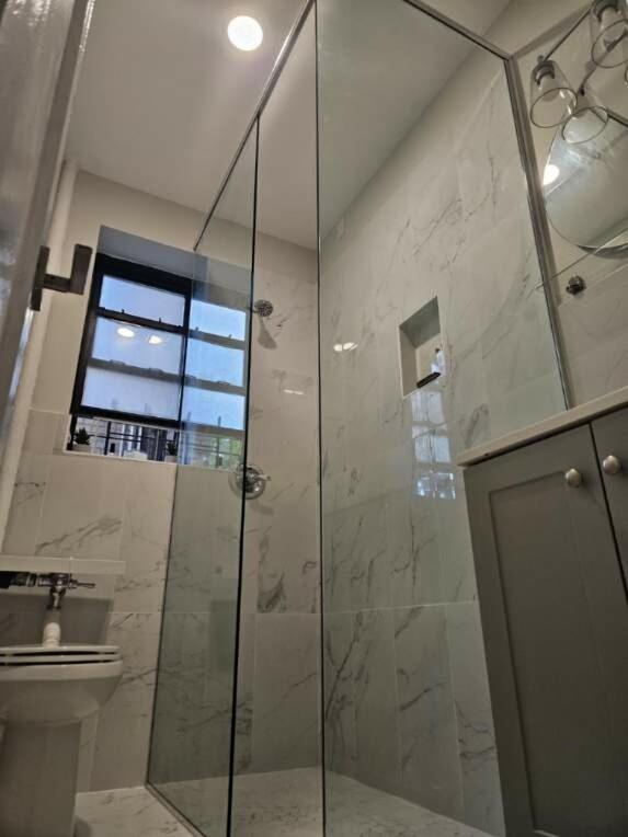 a bathroom with a glass shower with a toilet at Brooklyn retreat 1 in Brooklyn