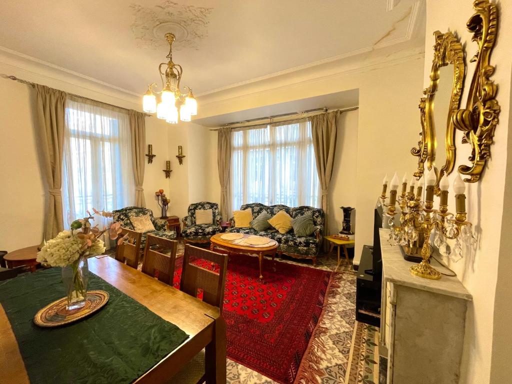 a living room with a couch and a dining room at Appartement Dans Immeuble Haussmanien in Alger