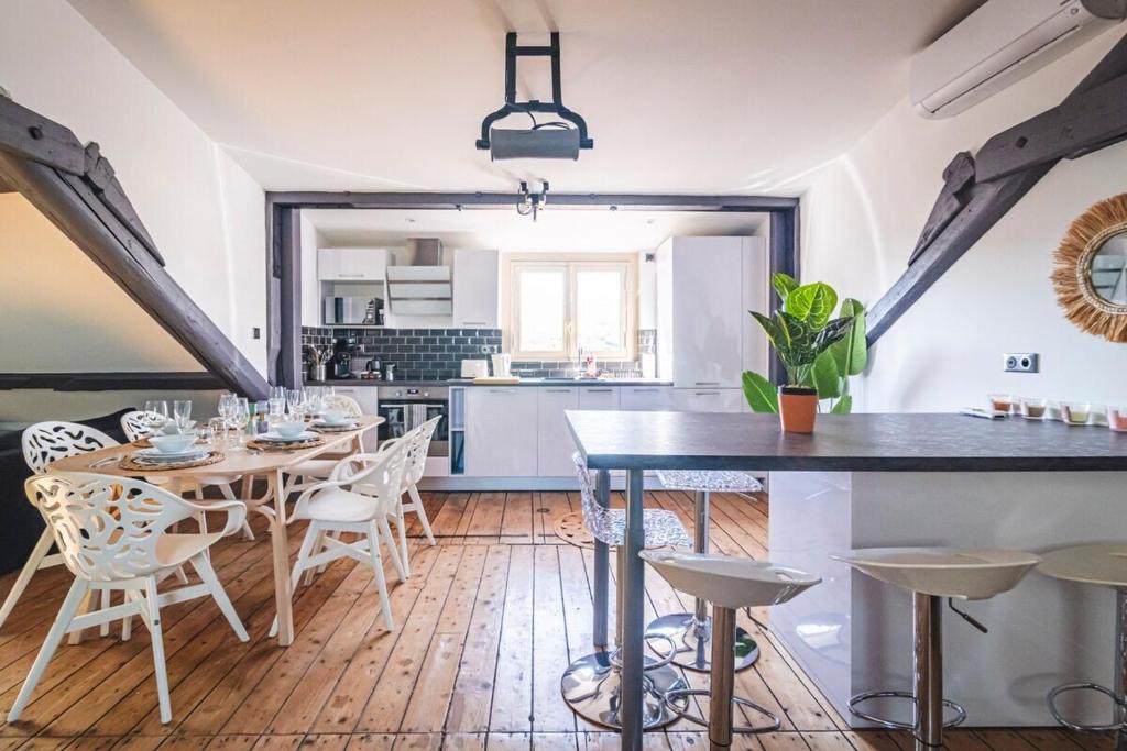 een keuken en eetkamer met een tafel en stoelen bij Le nid Perché # reims in Reims