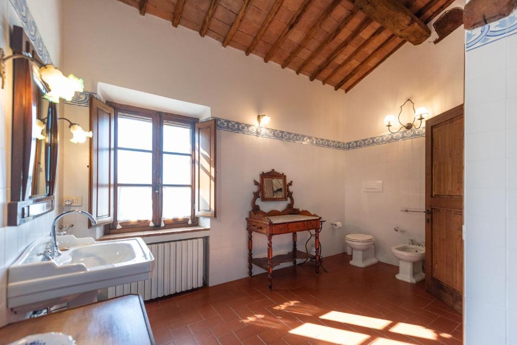 une salle de bain avec un lavabo et des toilettes et une fenêtre dans l'établissement Villa Santa Virginia, à Sienne 58 autres photos