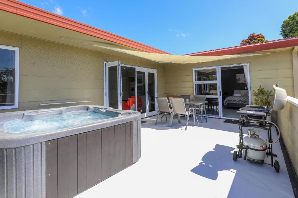 a hot tub on the patio of a house at Stay at 5A in Rotorua