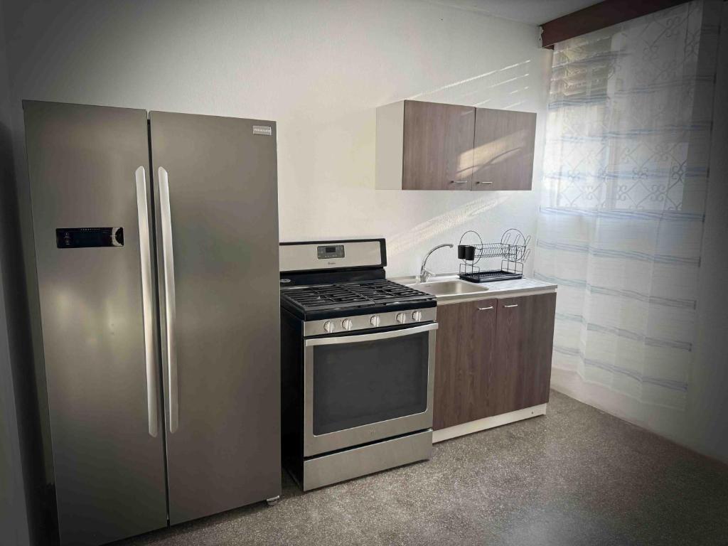 a kitchen with a stainless steel refrigerator and a stove at Casa a 8min del aeropuerto. Z11 in Guatemala