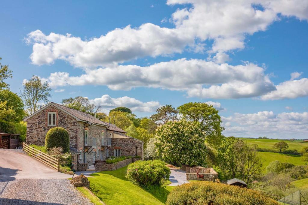 una finca con una casa de piedra con entrada en Meavy Cottage en Totnes