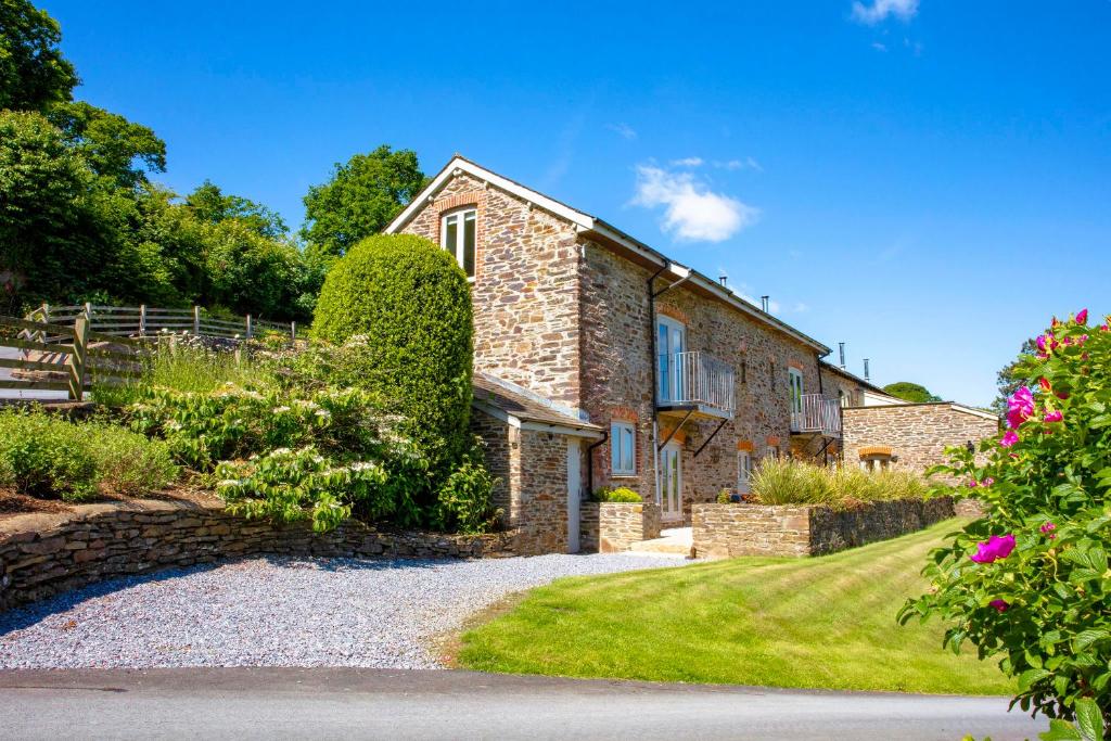 a stone house with a garden in front of it at Maristow Cottage in Totnes