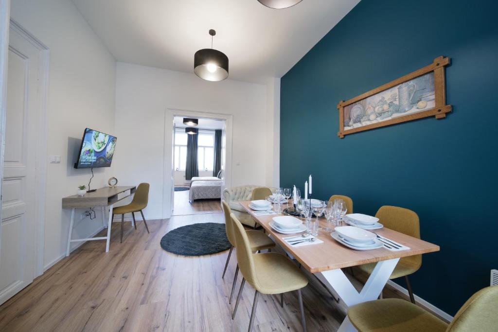 a dining room with a table and a blue wall at Majestic Square View Residence in Prague