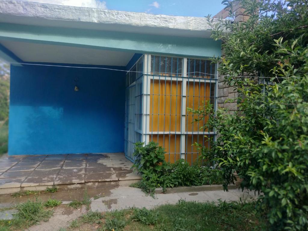 a blue house with a yellow door in front at Pachamama in Uspallata