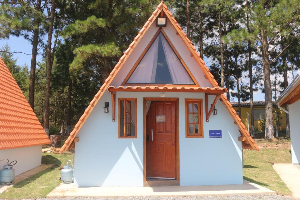 a small house with a pointed roof and a door at Sítio Terra Sertaneja - Chalé Estou Apaixonado in Turvo dos Góis