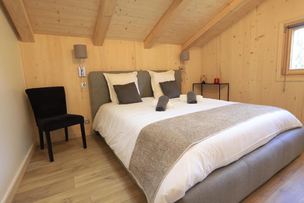 a bedroom with a large bed and a chair at Chalet du Bonheur in Saint-Gervais-les-Bains