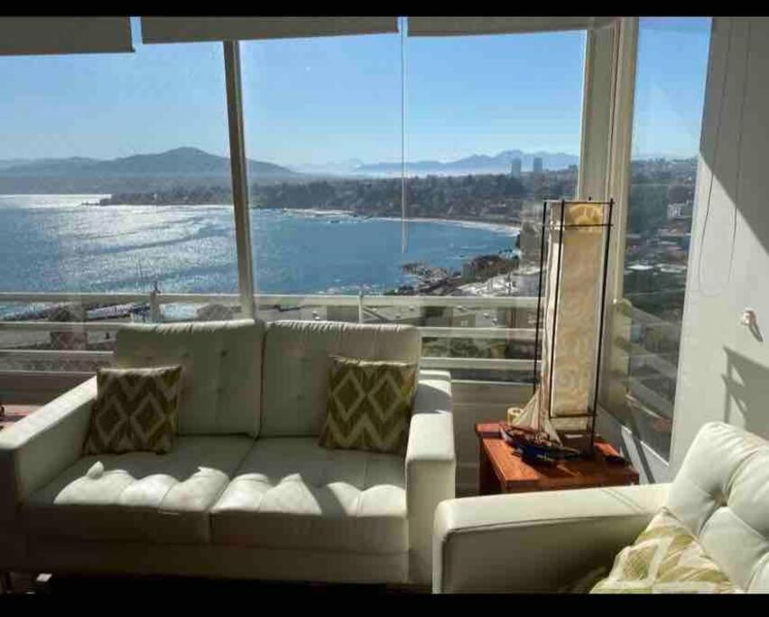 uma sala de estar com um sofá branco e uma grande janela em Precioso depto vista al mar Concon Condominio Tipo Resort 2 dormitorios em Concón