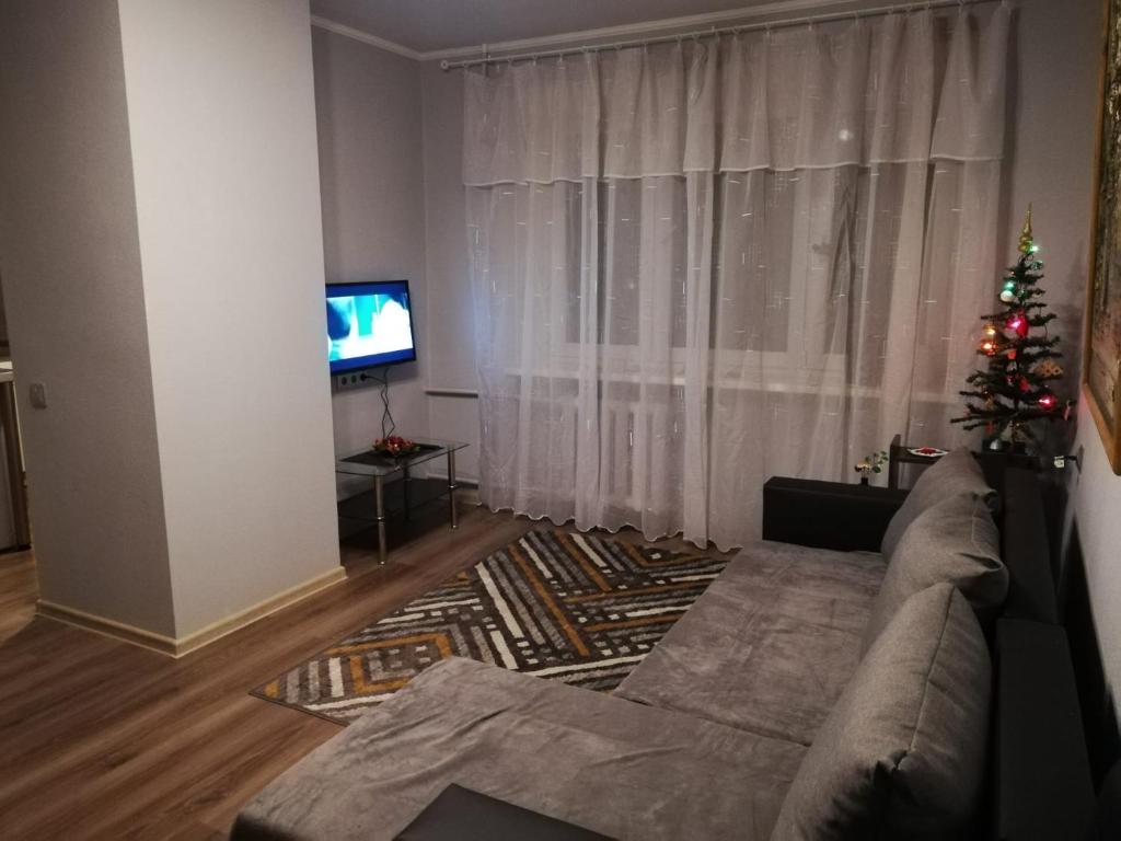 a living room with a christmas tree and a couch at Saknes apartamenti in Rīga