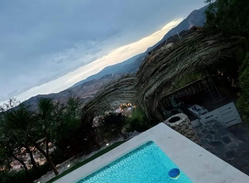 uma piscina de beiral infinito com vista para o oceano em Casa Cueva "El Mirador de Piedra" em Pegalajar