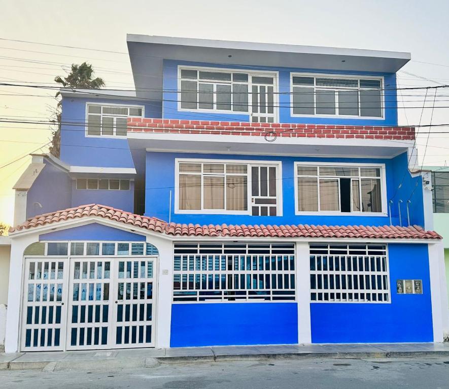 una casa azul y blanca con una puerta blanca en la casa azul, en Huarmey