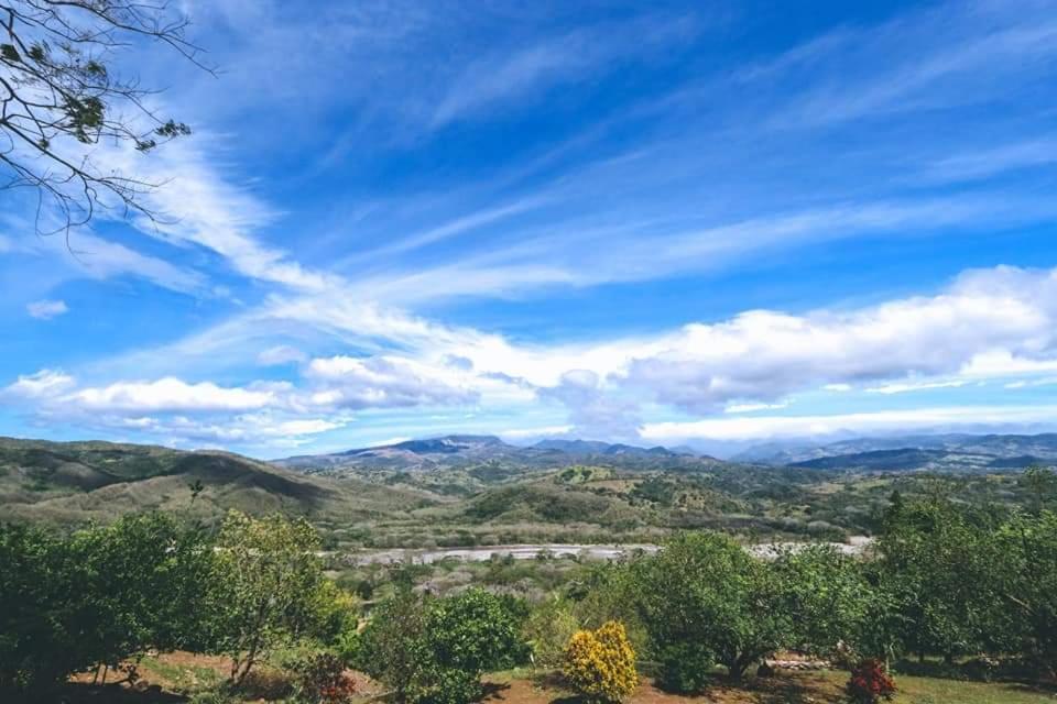 Blick auf ein Tal unter einem blauen Himmel mit Wolken in der Unterkunft Disfruta del contacto con la naturaleza in Puntarenas