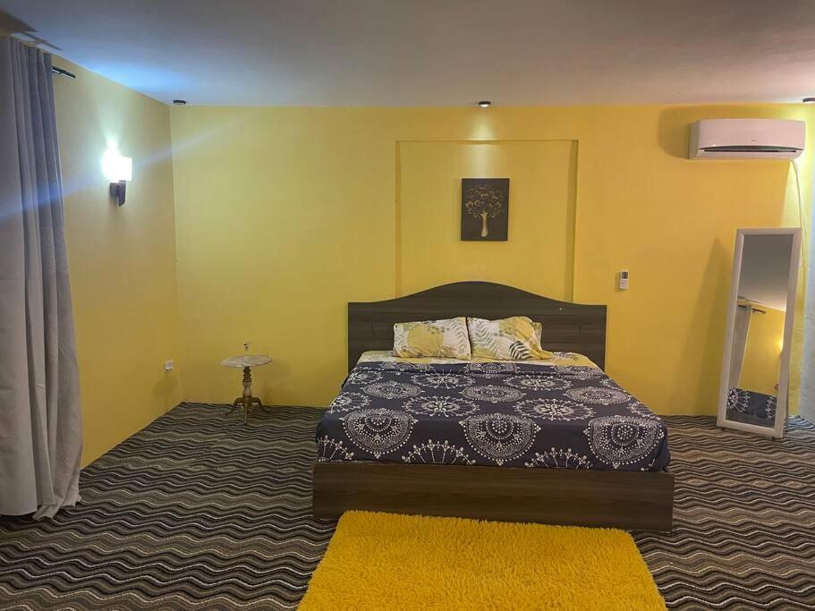 um quarto com uma cama e uma parede amarela em Heaven Corner with Mountain Sunset and Seaview 
