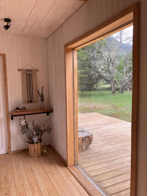 a sliding glass door in a room with a deck at Preciosa casa V. Cerro Castillo cercana Parque in Villa Cerro Castillo