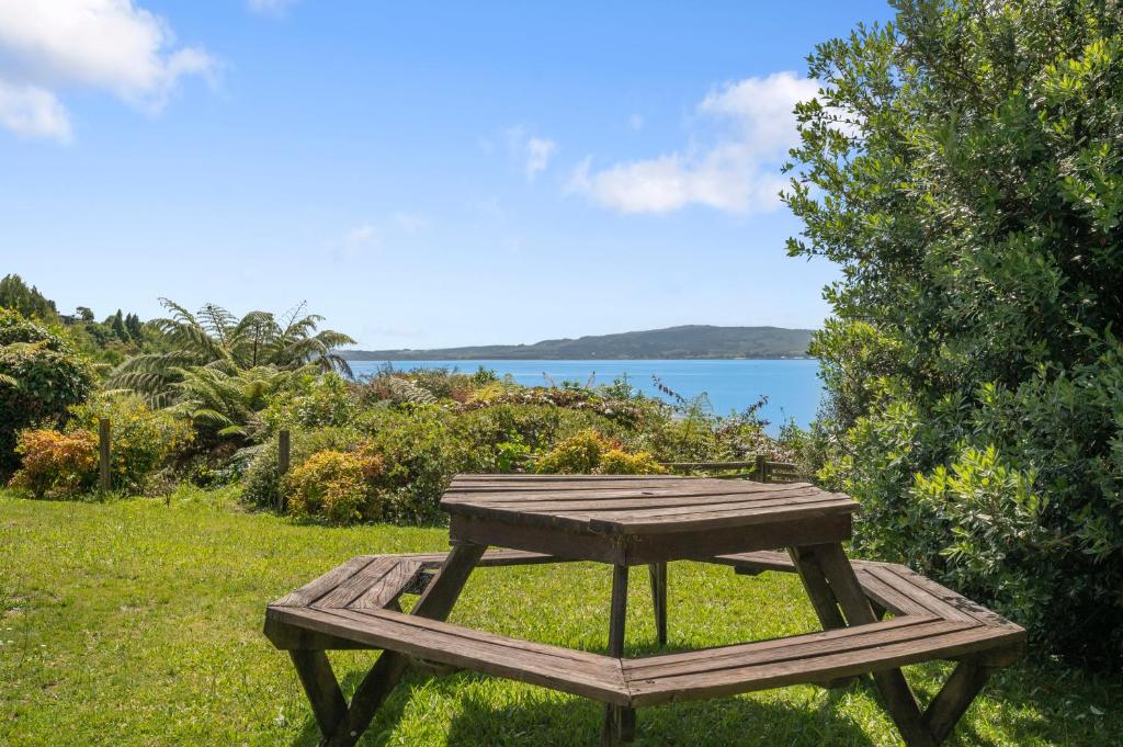 a wooden picnic table in the grass near the water at Kawaha on the Lake in Rotorua