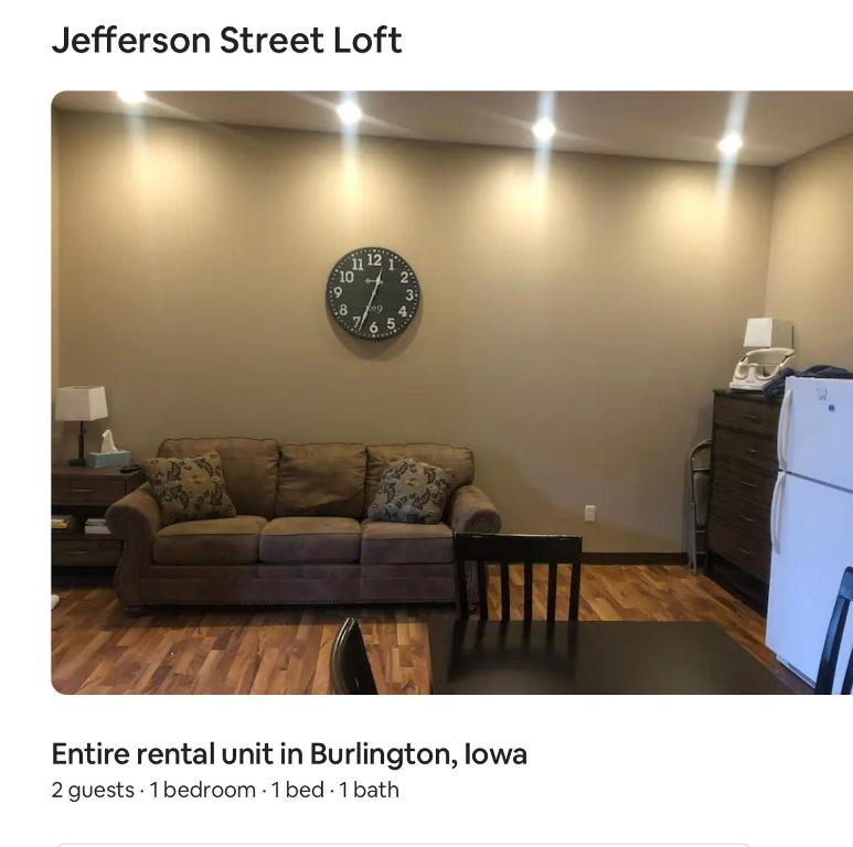 - un salon avec un canapé et un réveil sur le mur dans l'établissement Jefferson street Loft, à Burlington