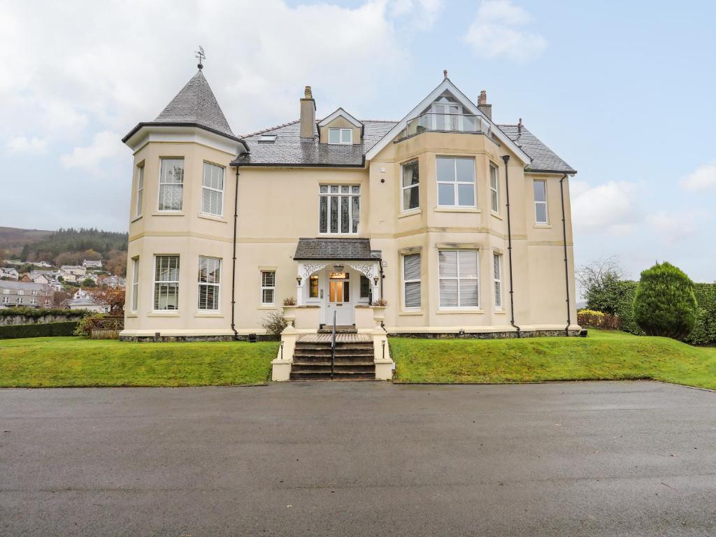 a large white house with a roof at Plas Meirion Apartment 3 in Trefriw