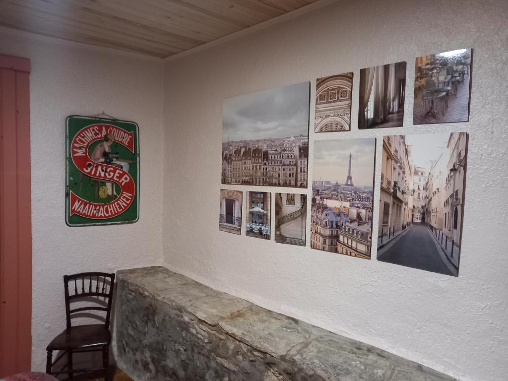 a room with pictures on a wall with a chair at L&#39;Armandière, maison de caractère où règne calme et sérénité. in Pézenes-les-Mines