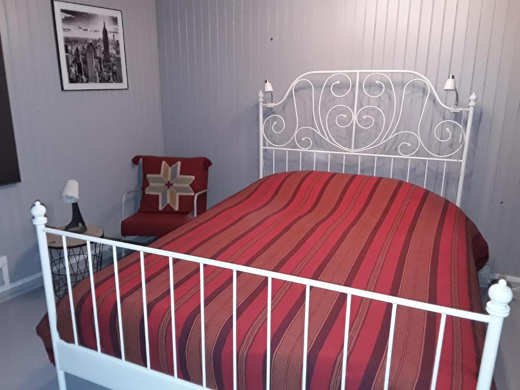 a bedroom with a white bed with a red blanket at L&#39;Armandière, maison de caractère où règne calme et sérénité. in Pézenes-les-Mines