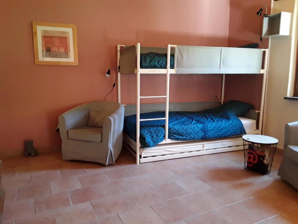 a bedroom with bunk beds and a chair at L&#39;Armandière, maison de caractère où règne calme et sérénité. in Pézenes-les-Mines
