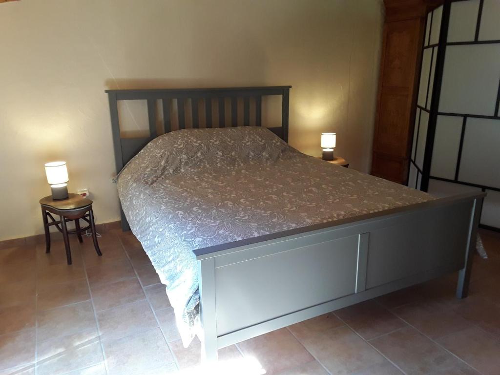 a bedroom with a bed with two lamps on two tables at L&#39;Armandière, maison de caractère où règne calme et sérénité. in Pézenes-les-Mines