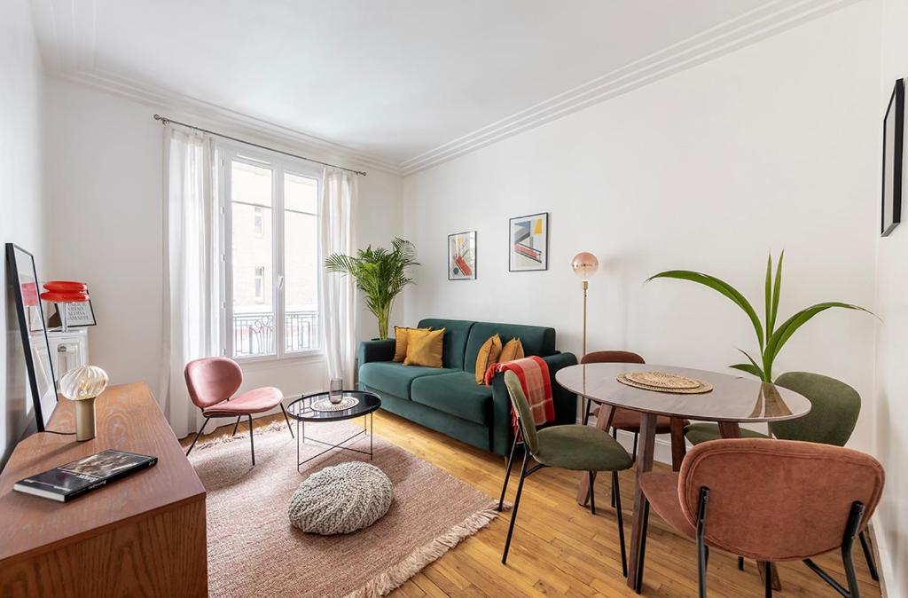 a living room with a green couch and a table at Nouveau T2 à 7 min de Saint-Lazare in Asnières-sur-Seine