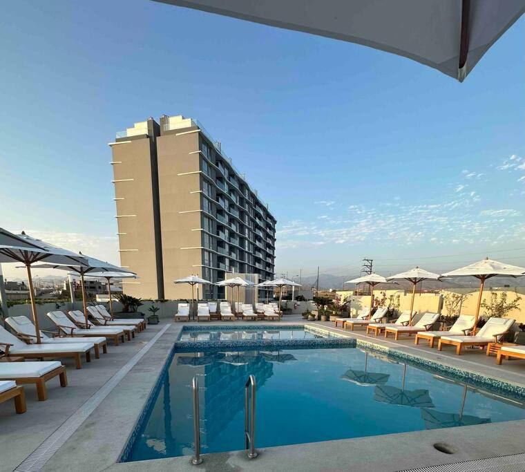 una piscina con tumbonas y un hotel en Apartamento de estreno San Bartolo vista Piscina Playa en San Bartolo