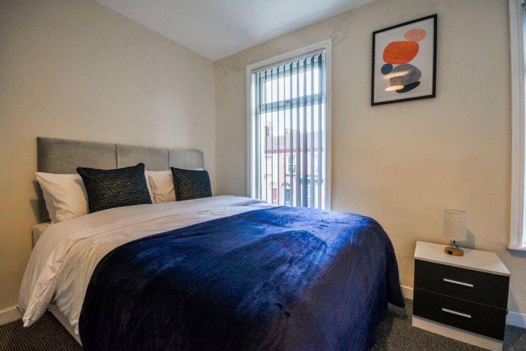 a bedroom with a large bed and a window at Sleeps 7 guests, great location in Liverpool