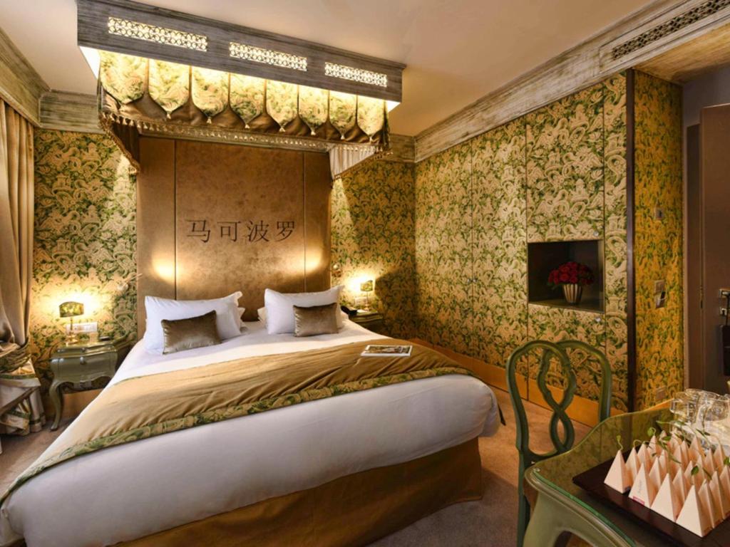a bedroom with a large bed in a room with wallpaper at Hotel Papadopoli Venezia - MGallery Collection in Venice