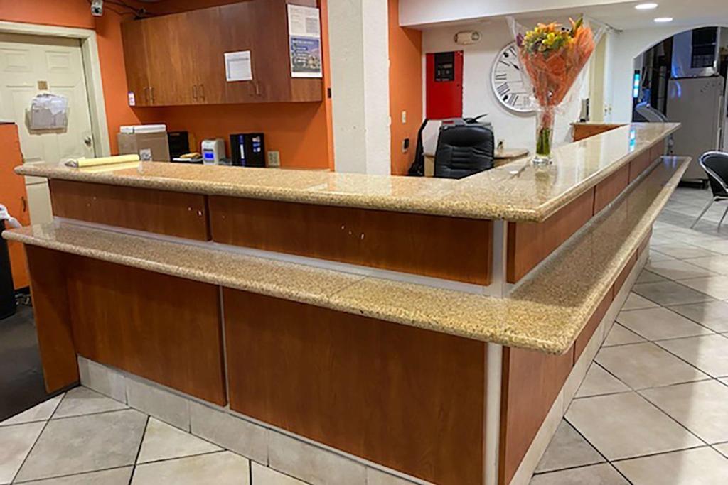 a lobby with a reception counter with a vase of flowers at Travelodge by Wyndham San Antonio Lackland AFB North in San Antonio