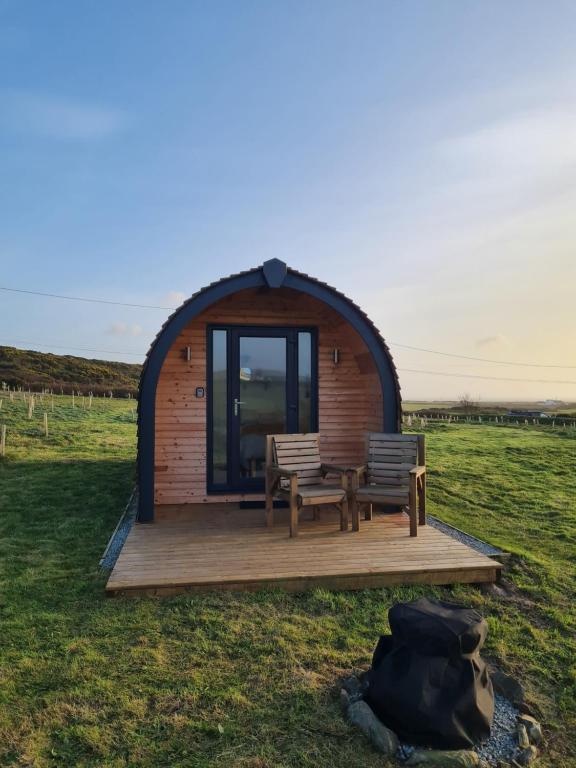 a gazebo with two benches and a table and chairs at Two Peas in a Pod in Holyhead