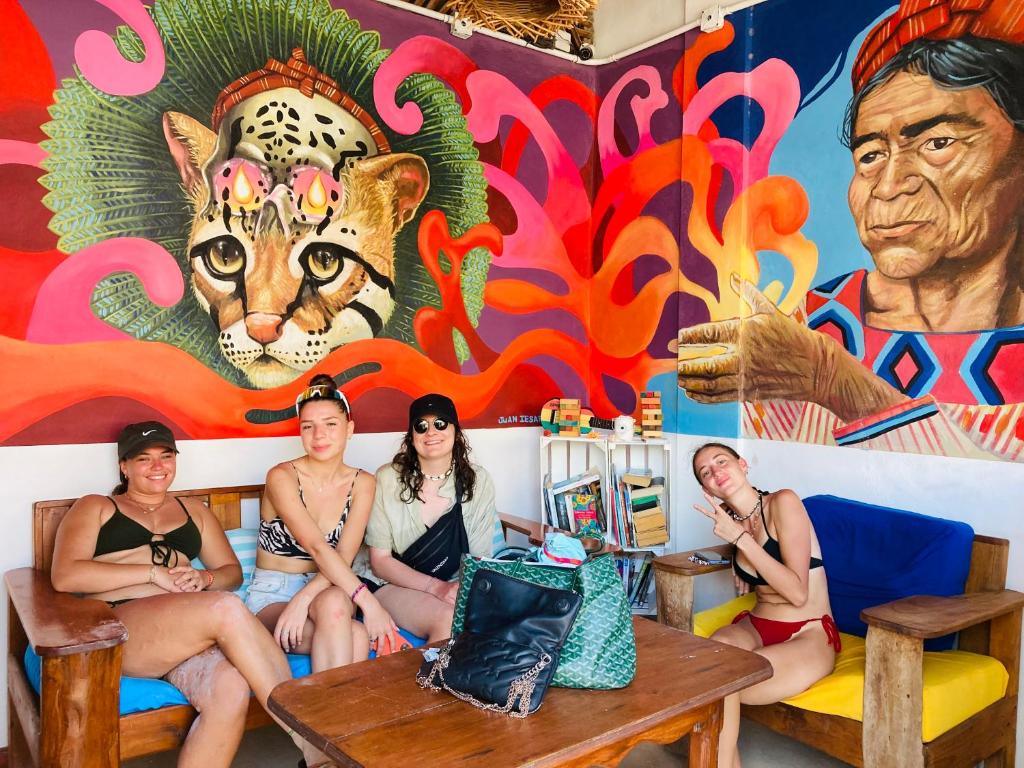 a group of women sitting in front of a mural at HOLBOX HOSTAL in Holbox Island