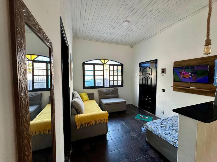ein Wohnzimmer mit einem Sofa und einem TV in der Unterkunft Casa aconchegante em Peruíbe in Peruíbe