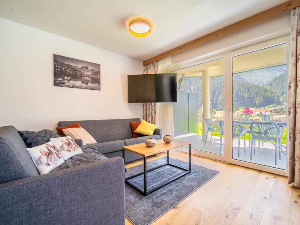 ein Wohnzimmer mit einem Sofa und einem Tisch in der Unterkunft Chalet Pettneu am Arlberg - Top 1 in Pettneu am Arlberg