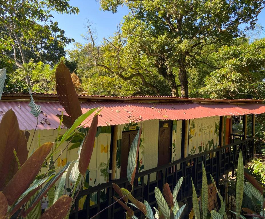 une maison avec un toit rose et une clôture dans l'établissement Hostal Las Mariposas Minca, à Minca
