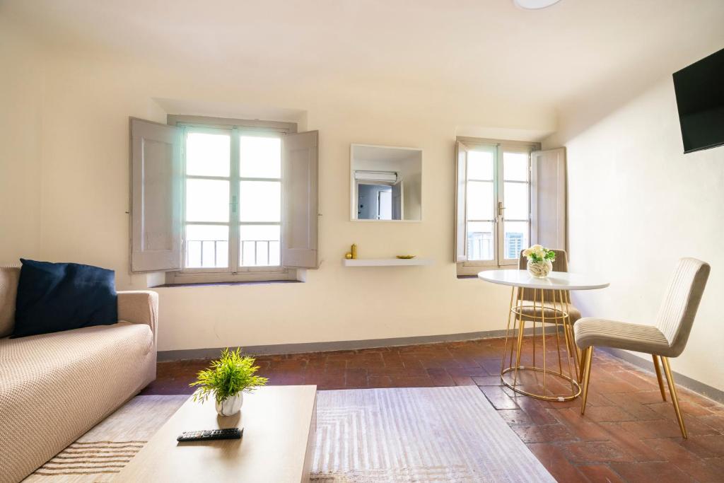 フィレンツェにある[Piazza Pitti]Luminoso Appartamento con Terrazzo e Parcheggio su richiestaのソファとテーブルのあるリビングルーム