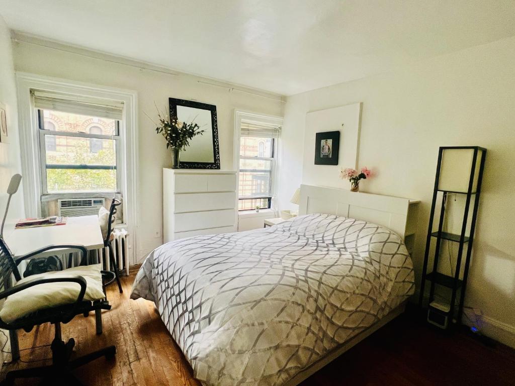 1 dormitorio con 1 cama, 1 silla y 2 ventanas en Prime Location- Central Manhattan, en Nueva York