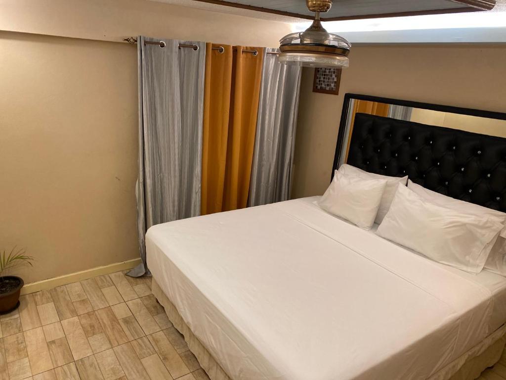a bedroom with a large bed with white sheets at Sunset condos getaway In Ocho Rios in Ocho Rios