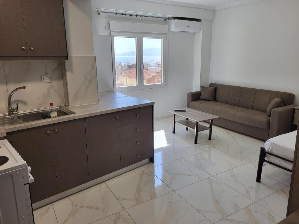 a kitchen and living room with a couch and a table at City Stay Kavala in Kavala