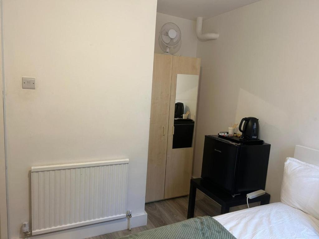 a bedroom with a bed and a dresser and a mirror at Lovely Double Rooms in Euston & Square in London