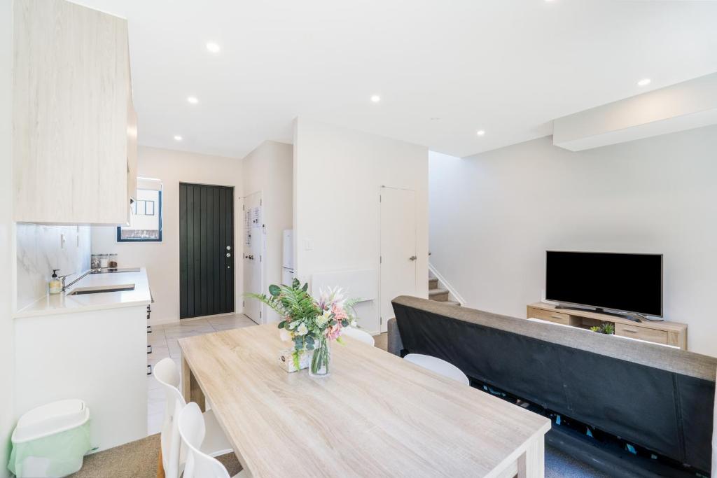 - une cuisine et une salle à manger avec une table et des chaises dans l'établissement Cozy Brand New Townhouse 18, à Auckland