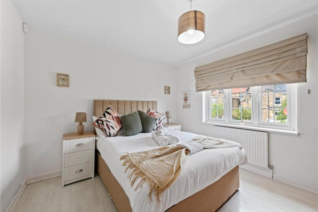 a bedroom with a large bed and a window at Huge Home by Station / Gym & Garden in London