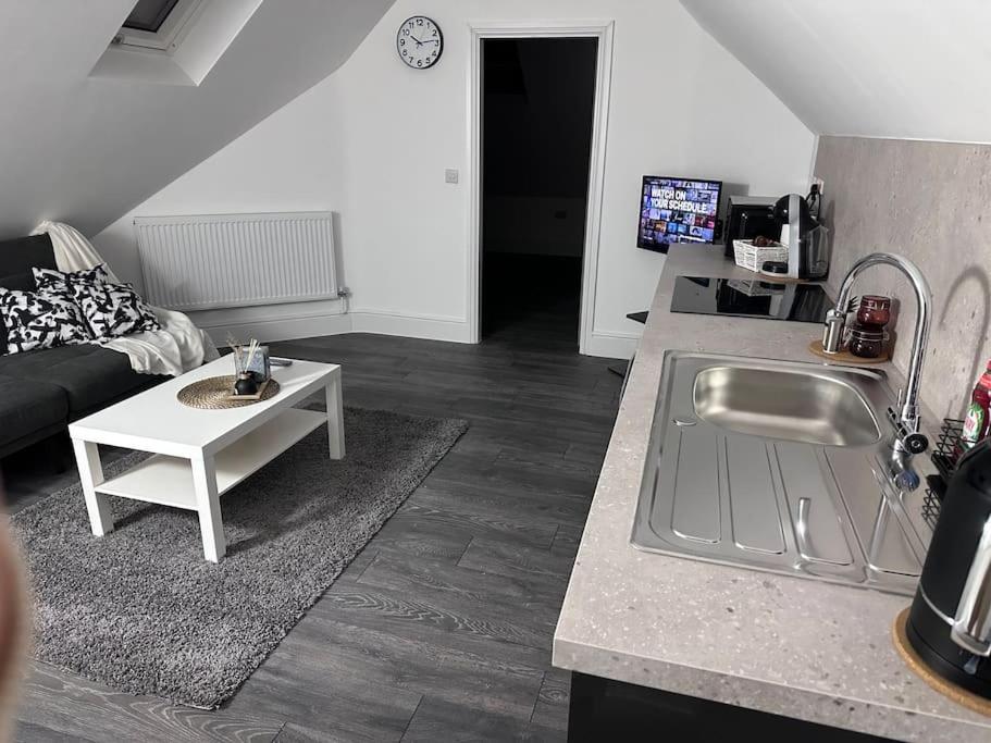 Una cocina y una sala de estar con un sofá y una mesa. en Flat in Leicester!, en Leicester