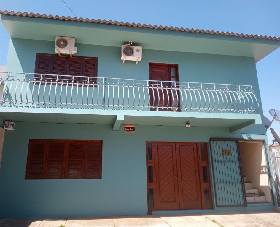 Casa azul con balcón y 2 puertas en La posada en São Gabriel