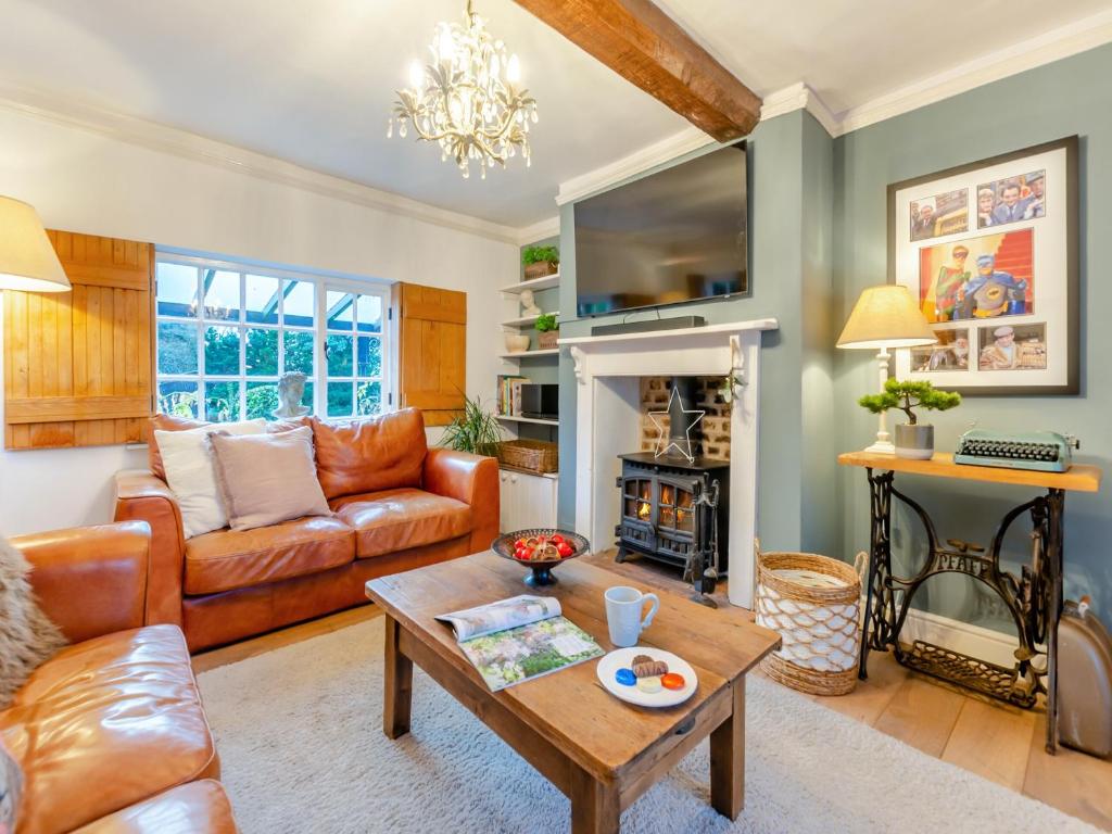 a living room with a couch and a table at The Cottage in Hungerton
