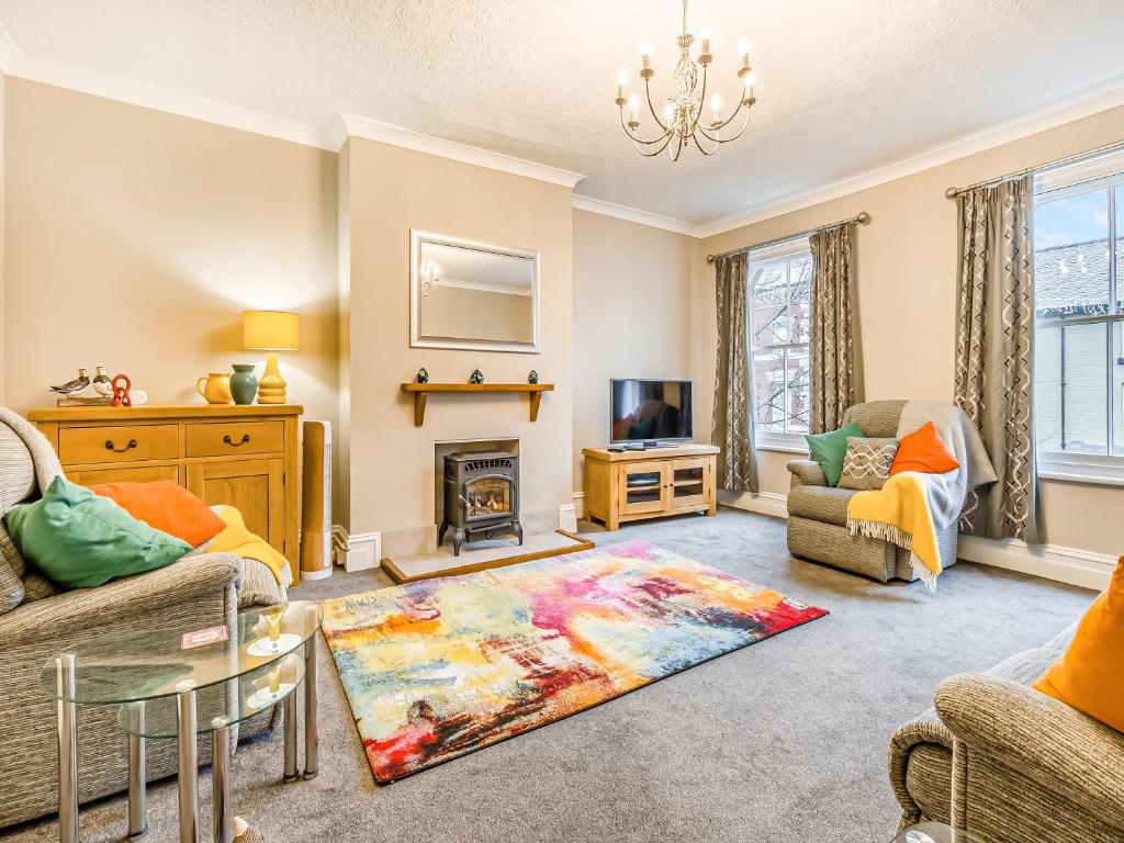 a living room with a couch and a fireplace at Cobblers Flat in Llanidloes