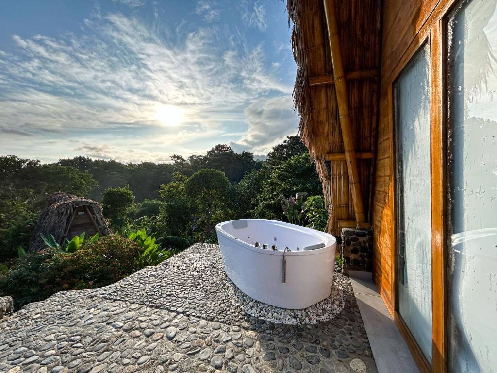 塞諾的住宿－Ecohabs Bamboo Parque Tayrona - Dentro del PNN Tayrona，浴缸位于房子的阳台上